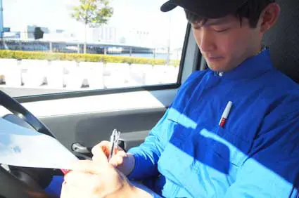 運転日報を手書きで書くドライバー